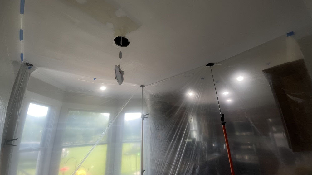 Wide angle view of sealed plastic containment chamber tight to ceiling molding